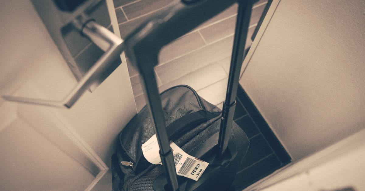 Valise de voyage près d'une porte avant un départ en vacances